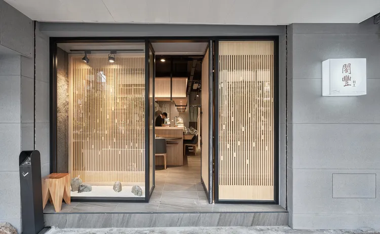 入口處以落地玻璃窗搭配主理人收藏石頭玩物，引領饕客進入割烹與藝術交織的新天地。業者提供