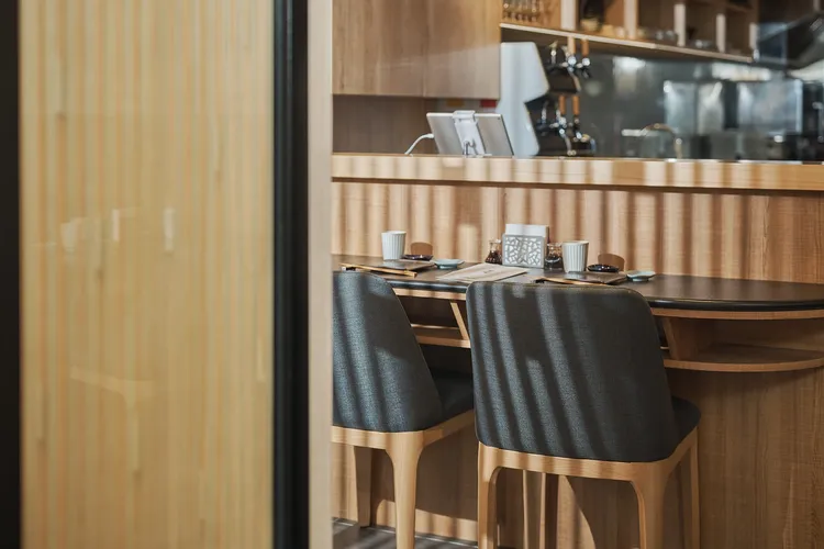 《閤豐割烹》的空間設計是從食材「原味」的延伸，一樓板前用餐區利用手工切割檜木隔板，與室外光影照入的層疊感，呈現出愛與溫暖氛圍。業者提供