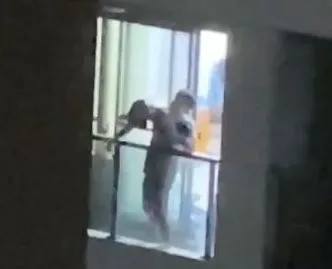 父親作勢將兒子丟下樓。翻攝畫面