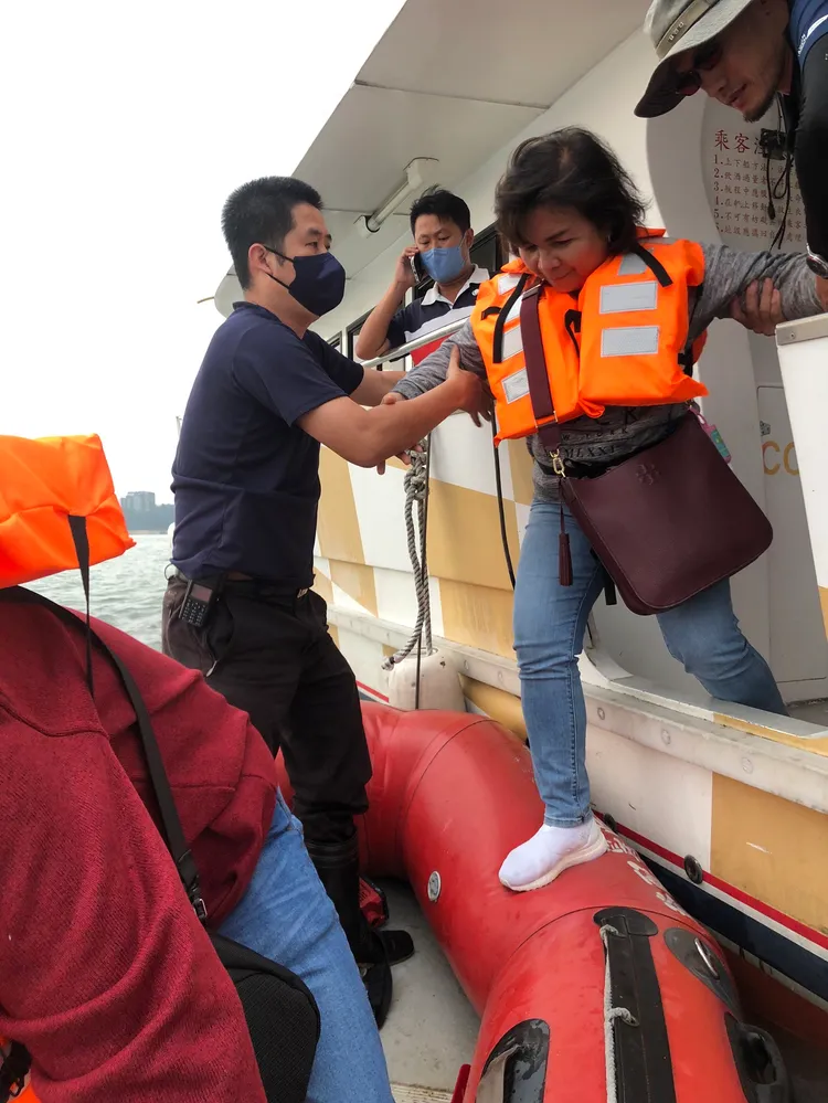 消防人員出動快艇，將受困船上遊客接駁上岸。讀者提供