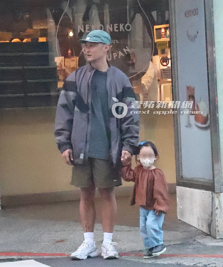 將車開到住家附近後，余文樂（左）牽著余初心準備過馬路。特勤中心攝