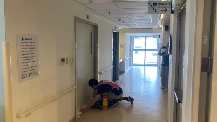 機構人員將門縫塞住避免濃煙進入屋內。新北市消防局提供