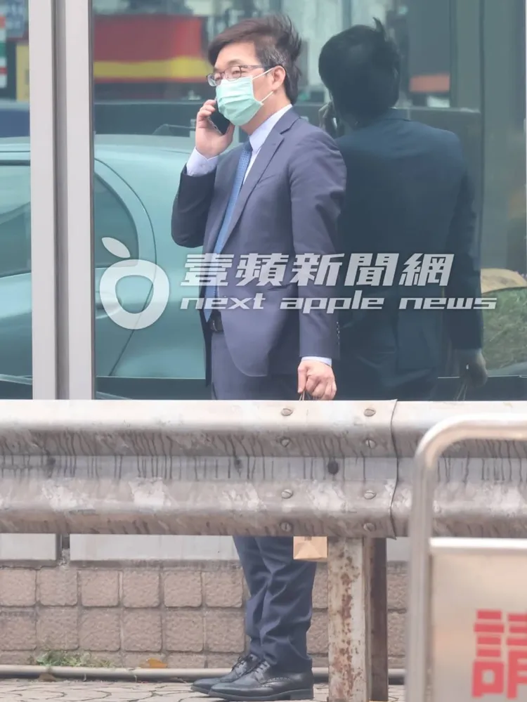邱仲峯提著一袋在外頭講電話，看來公事繁忙。特勤中心攝