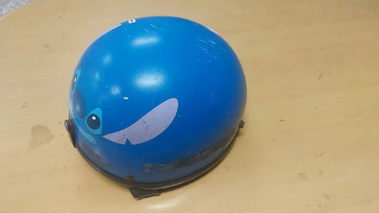 被害人遭卡通安全帽毆頭。讀者提供