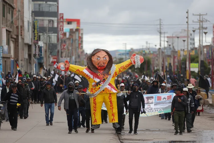 反政府抗議者持新總統博魯阿爾特傀儡，在它身上寫「謀殺者」，指控她鎮壓示威導致抗議者喪命。路透