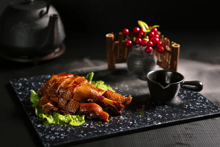 透著晶亮醬色的冰糖醬鴨吃來軟中帶嚼勁，微甜芳香多吃幾塊也不會膩。業者提供