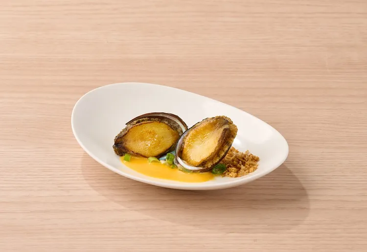 出示王品瘋美食APP上活動畫面，可享贈菜「金沙鮑魚」一份。業者提供