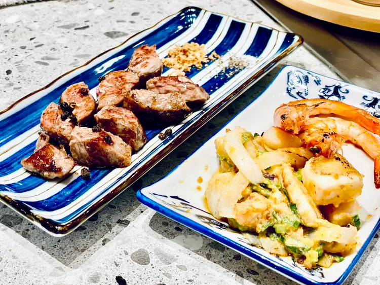 「就饗鐵板燒」主打「澎湃海陸雙主餐」，不論點牛排或雞腿排均附贈包含金沙雙魷+白蝦的海鮮盤。曾仲葳攝