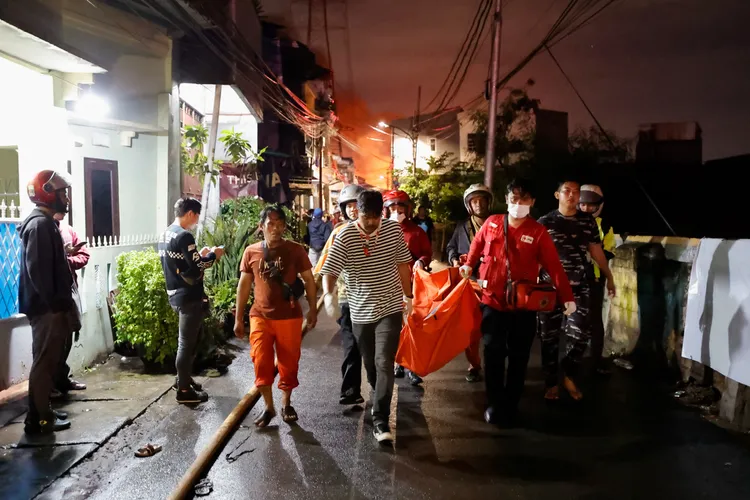消防員抬著遺體。路透社