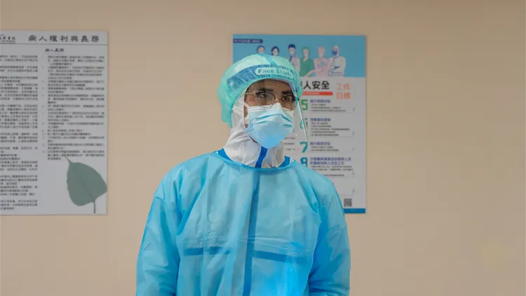 梁正群穿三層防護衣後，更敬佩醫護人員。大愛提供