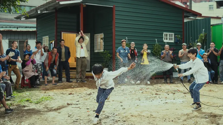 《做工的人 電影版》蓋好新的鐵皮屋之後，眾人在屋外歡樂打水仗。大慕影藝、華映娛樂提供
