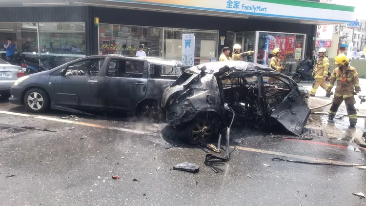 黑色小客車被燒成如廢鐵，波及一旁停在路邊的小客車。讀者提供