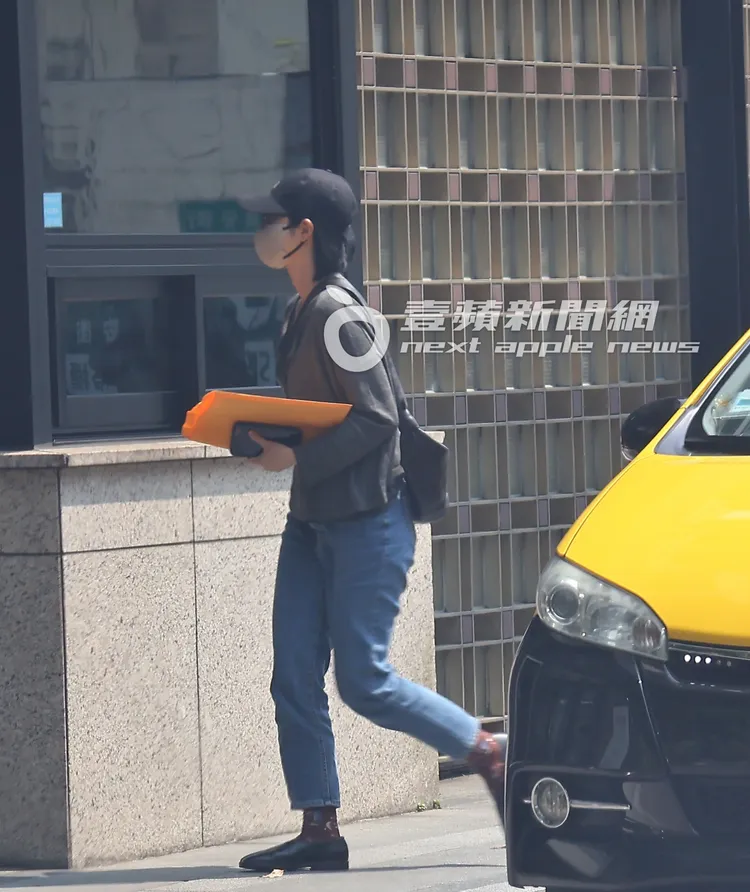 桂綸鎂手上拿著文件袋及錢包，頭也不回地走進家門。特勤中心攝