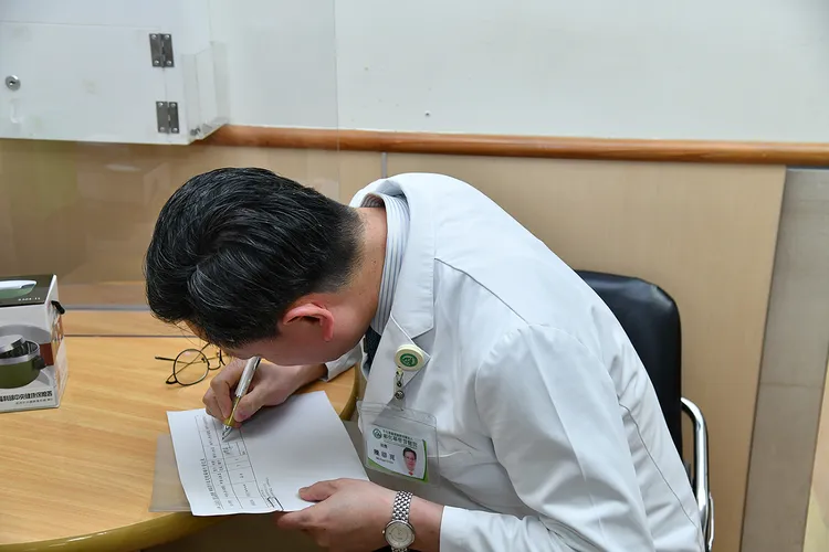 陳穆寬（左）代表外籍傷患簽收健保卡。彰基提供