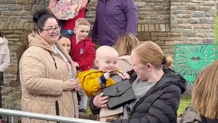 1歲男娃拿著凱特王妃的Mulberry手提包非常開心。翻攝ITV