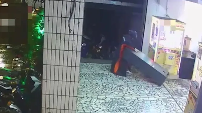 何男將兌幣機拉出店外欲破壞。板橋警分局提供