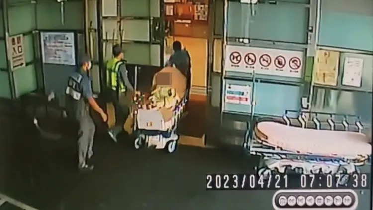 獨活的8歲男童意識清醒地坐在擔架上被推進急診室。翻攝畫面