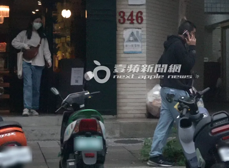 Leo王（右）在工作室外講了許久電話，接著與一名年約30歲左右的女子離開。特勤中心攝