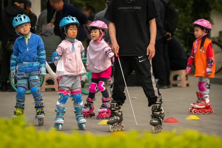 青年連自己都養不起，更不敢生養孩子。圖為上周北京一座公園中孩子跟著教練學直排輪。美聯社