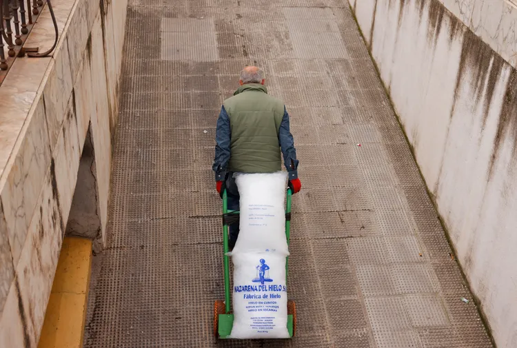 隆達（Ronda）一名工人拉著裝有冰塊的推車。路透社