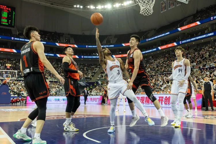 CBA在14日的比賽中，上海久事（白色球衣）以108比104勝蘇州肯帝亞（黑橘球衣）。新華社