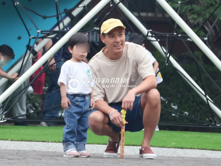 楊祐寧（右）蹲在女兒Anaheim 身旁，一同看著遠方小孩玩耍，畫面十分幸福。特勤中心攝