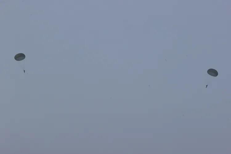 陸軍空訓中心「特種地形跳傘訓練班」今在屏東大鵬灣潟湖區操練水域進行跳傘訓練，降落指定水域後，再由橡皮艇人員接駁回岸上。讀者提供