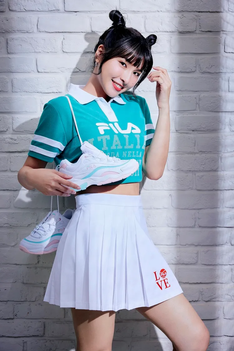 峮峮以FILA 2023春夏代表色銅綠呈現的FILA 1911印花Polo衫，搭配精緻刺繡點綴的百摺短裙，穿上限定台灣發行的母親節紀念版FILA RAY老爹鞋，展現復古潮流感的學院風格。品牌提供