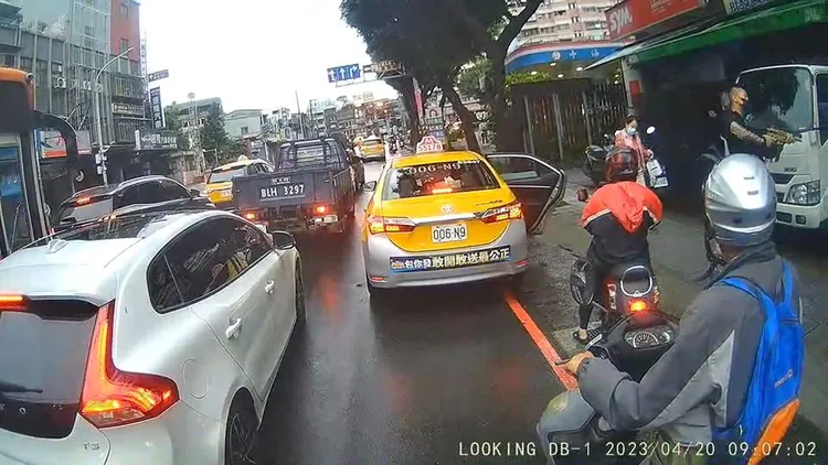 男子下計程車後隨即掏出衝鋒槍。讀者提供