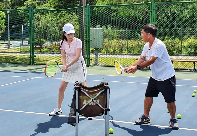 王曉書（左）在高溫下，頂著烈陽，跟聽障奧國手王俊偉學打網球，練基本功。 公視提供