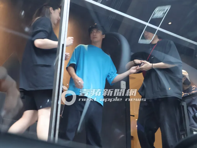 林哲熹（中）走到餐廳門口，拿手機給哥哥林頤原，讓他幫忙拍自己跟女友Cindy的合照。特勤中心攝