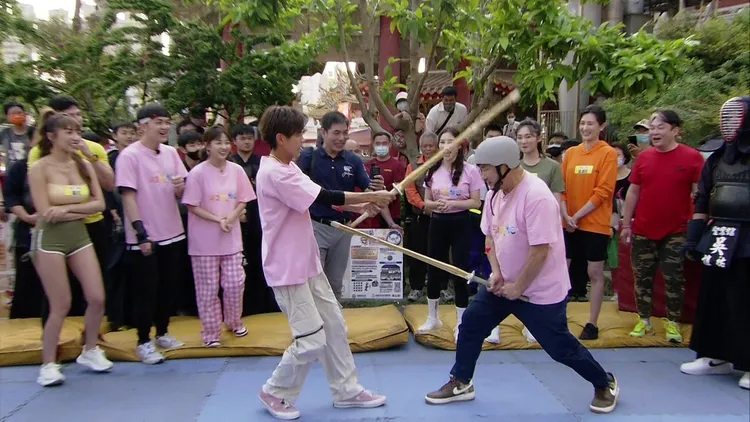 阿翔(左)拿木劍K胡瓜。民視提供