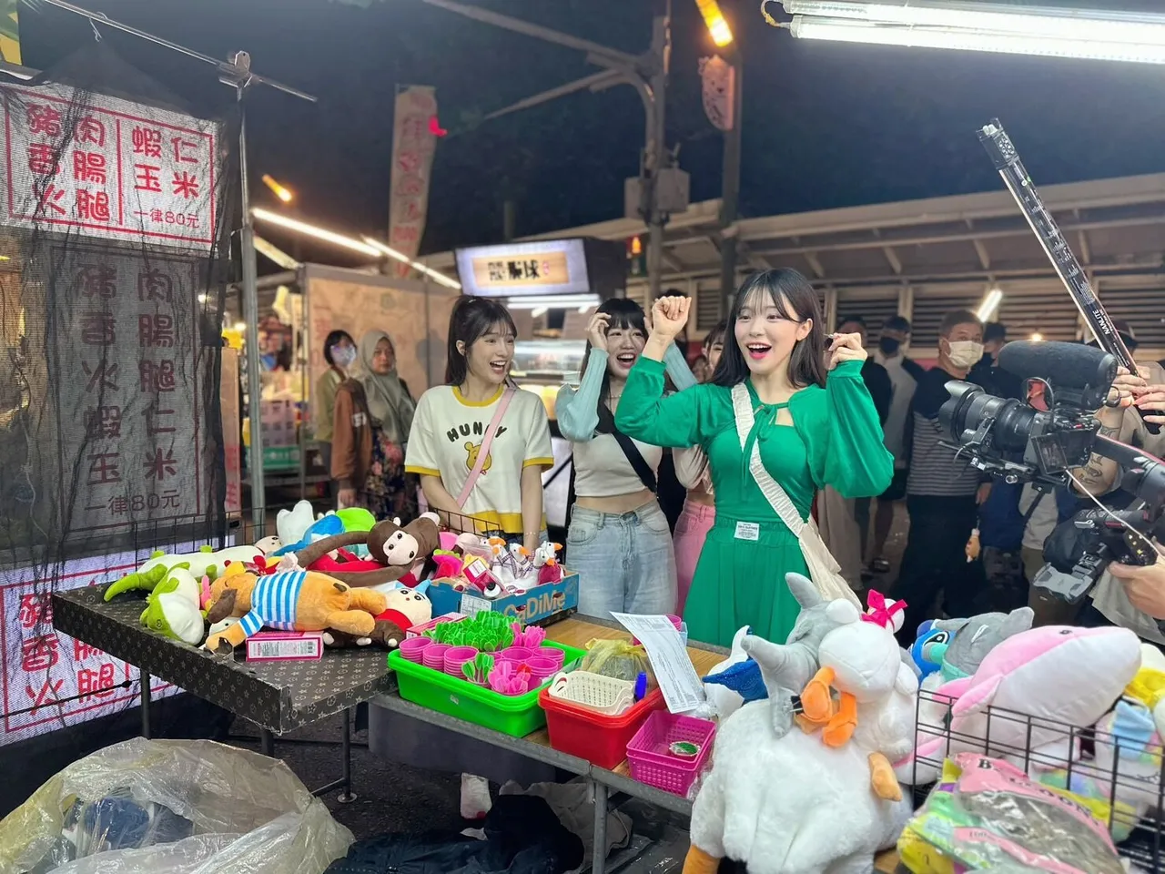 韓女神李多慧(右)首度體驗台灣夜市文化,玩射氣球遊戲贏得猴子玩偶獎品。樂天桃猿提供