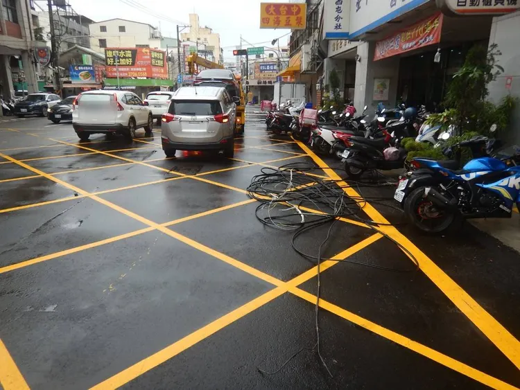 拖吊車吊桿勾落電纜線，導致吊纜線脫落波及瓶放路旁車輛。讀者提供