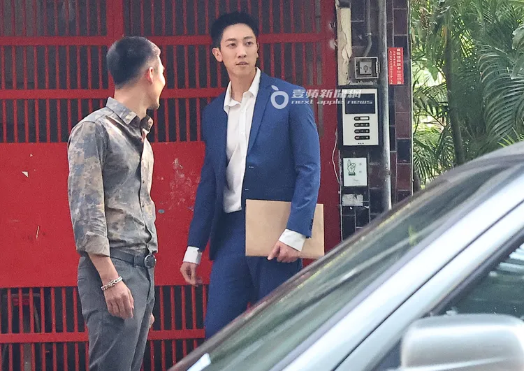 張哲偉（右）一身藍白西裝、手拿文件夾上戲。特勤中心攝