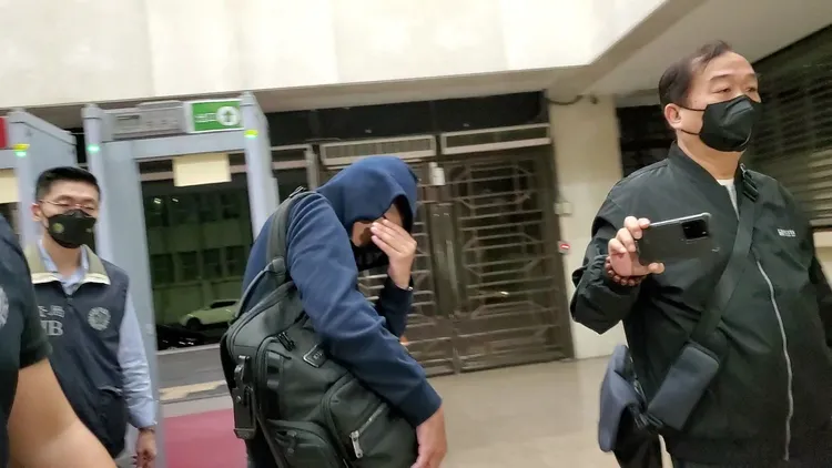 郭哲宇不斷遮臉躲避拍攝。呂志明攝