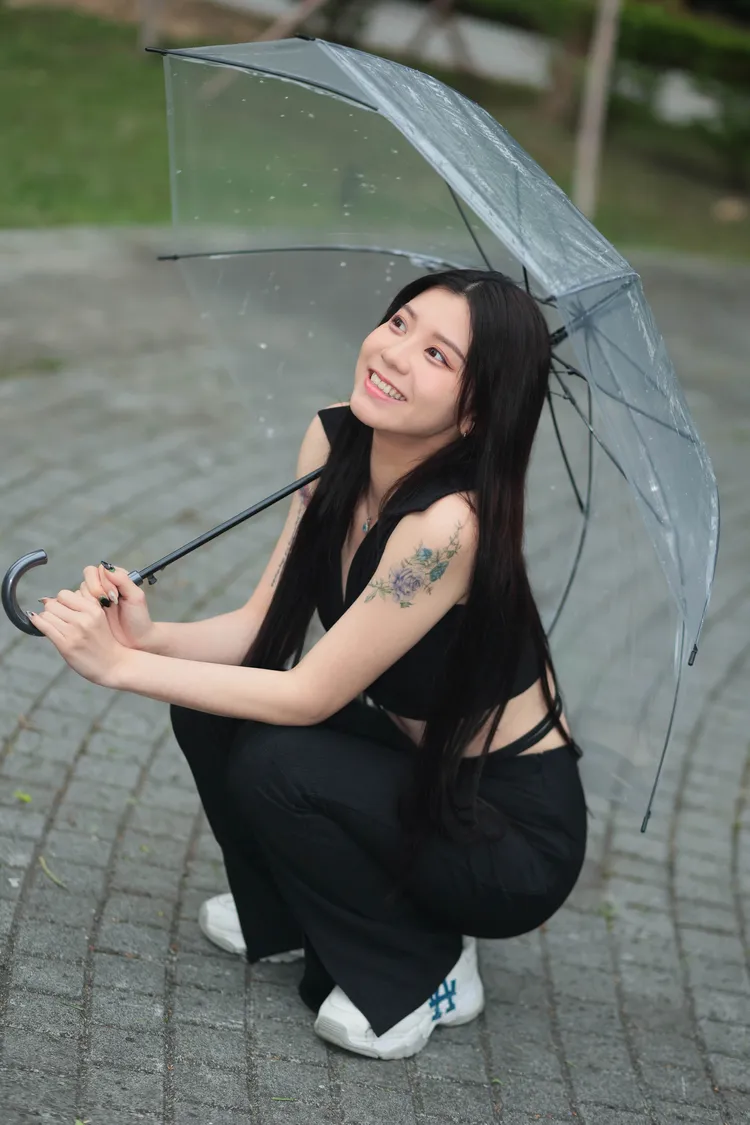 拿著小傘在雨中拍攝卡洛琳，反而有一種俏皮的感覺。彭欣偉攝