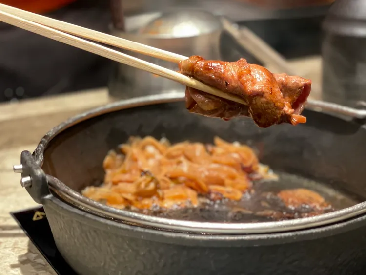 小橘色獨創「兼容式」壽喜燒，先以鑄鐵鍋炙燒和牛肉片品嚐。曾仲葳攝