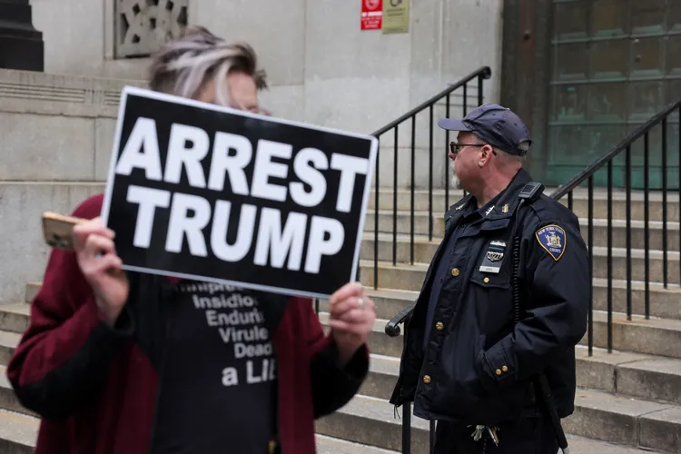 反川普民眾在他紐約寓所外舉牌「逮捕川普」。路透社
