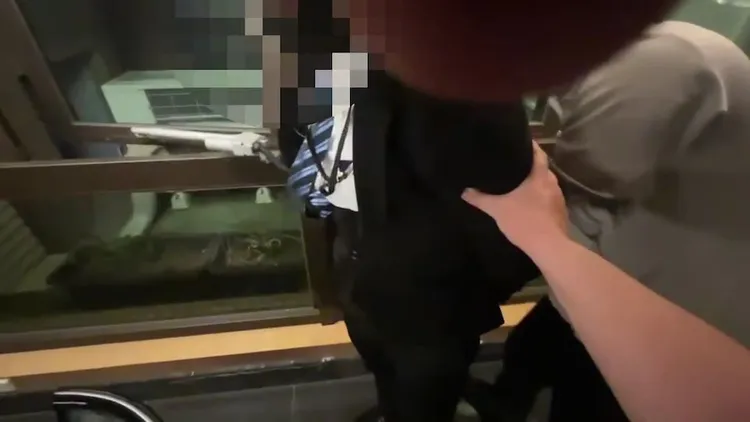 警方將全身西裝的車手鄭男上銬。蘆洲警分局提供