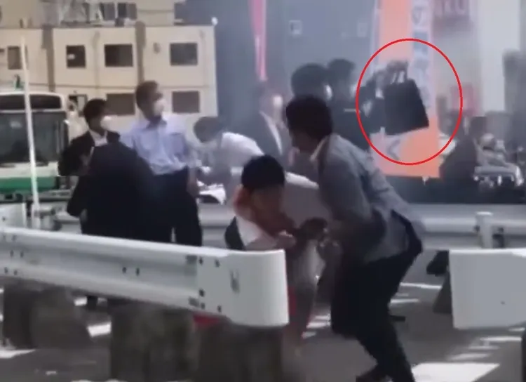 前首相安倍晉三去年在奈良遇刺，維安人員高舉公事包，卻未展開；安倍當時已中槍倒地。翻攝網路