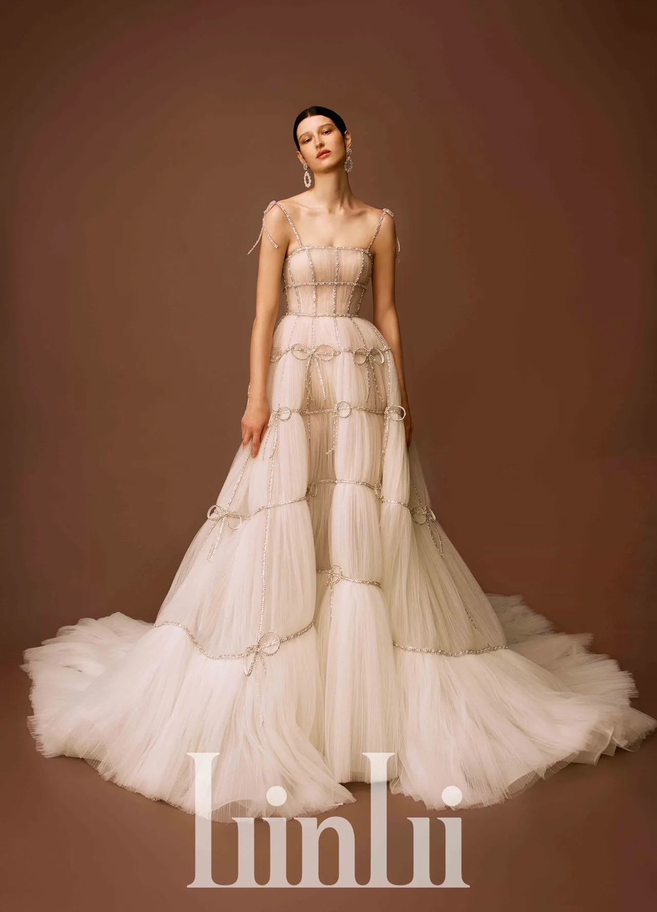 白标高订系列手缝水钻蝴蝶透视压褶白纱，以轻型结构搭配重工钻饰，透视铺压褶网纱上缝缀水晶珠条与蝴蝶结装饰，穿上后像一个包装精美的礼物。品牌提供