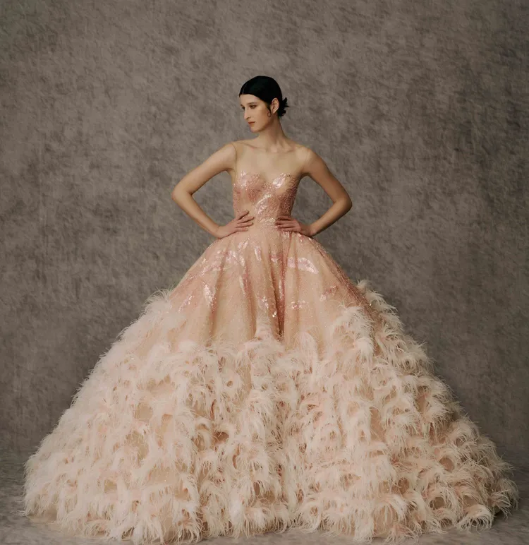 黑標頂級高訂系列蜜桃粉裸縫珠鑽羽毛禮服，背心式馬甲上身以手縫珠繡構成花形植物圖騰，並於蓬裙上縫飾600多朵羽毛手工花，堆出雲朵浪漫感。品牌提供