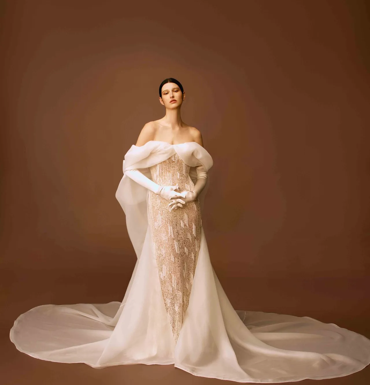 白标系列珠绣蕾丝窄摆白纱，透肤窄摆的珠绣蕾丝鱼尾线条搭配乌干缎立裁蝴蝶结披风设计，典雅又新颖。品牌提供 