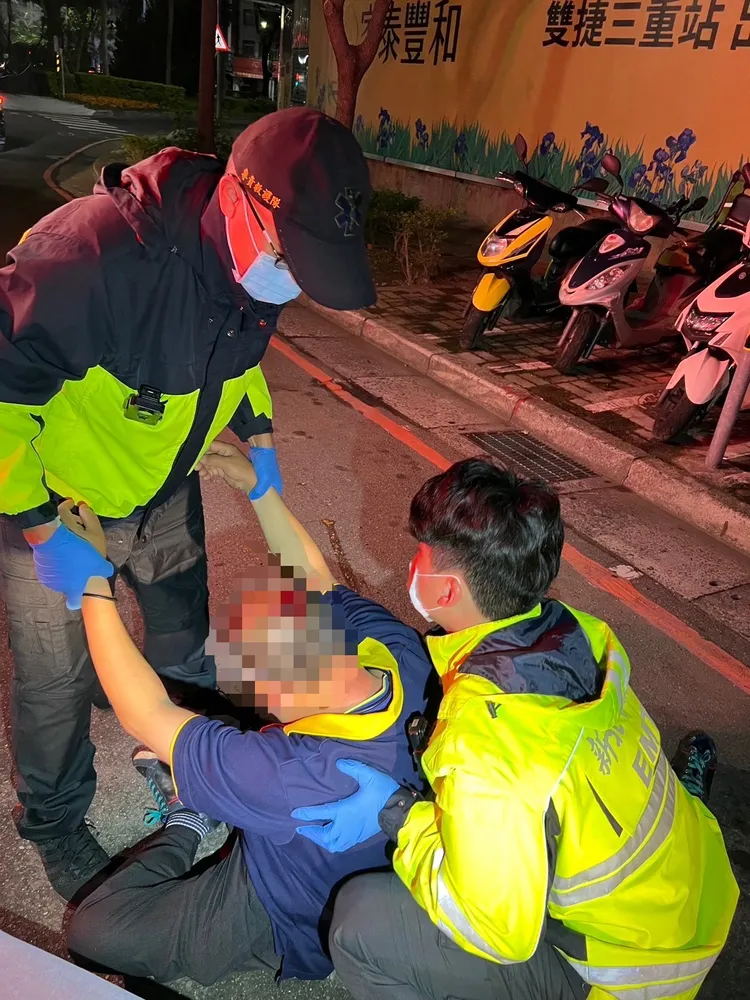 救護人員將李男抬上擔架。三重警分局提供