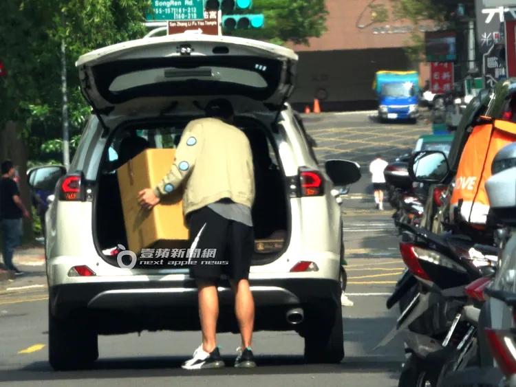 藍鈞天搬著一大箱紙箱貨物至後車廂。特勤中心攝