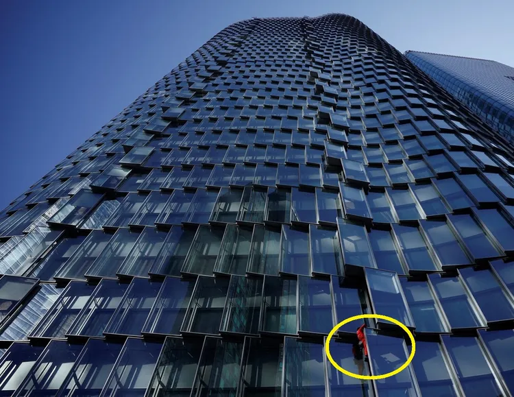 60歲的法國「蜘蛛人」羅伯特（黃圈處）原本再2年就可退休，現在必須延後，他拚老命爬摩天大樓抗議馬克宏的改革。路透社