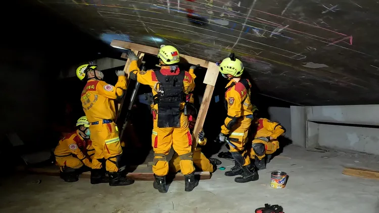 特搜隊人員使用木材支撐架穩固倒塌的樓板，避免再次坍塌。台中市消防局提供