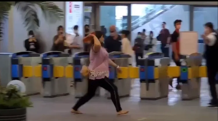 「要300姐」打著赤腳拎著拖鞋追打男姓站務員。翻攝即時事影音