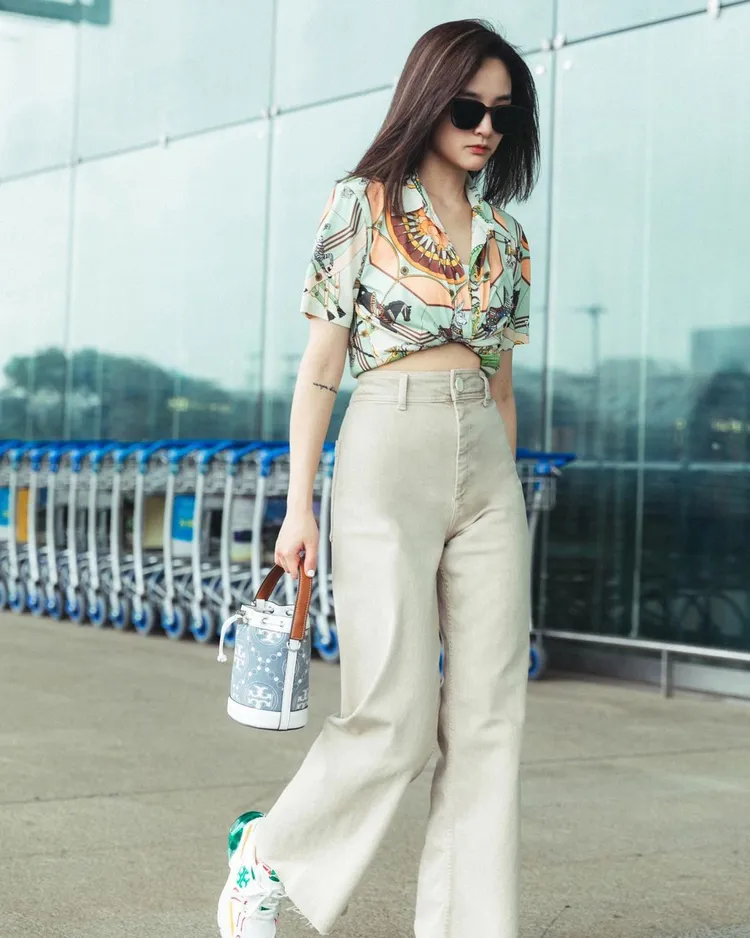 王淨受美國設計師品牌TORY BURCH的邀請，身著一襲露出小腹的印花襯衫造型飛往新加坡。翻攝_ginglebellaaa IG